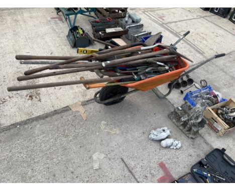 AN ORANGE PLASTIC WHEEL BARROW WITH A LARGE ASSORTMENT OF GARDEN TOOLS TO INCLUDE SPADES, FORKS AND SHEARS ETC 