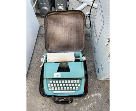 A PETITE JUNIOR PORTABLE TYPEWRITER WITH CARRY CASE 