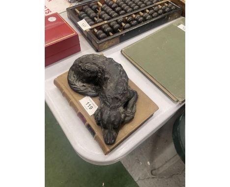 A HEAVY MODEL OF A SLEEPING DOG ON A STONEWARE BOOK, LENGTH 18CM, HEIGHT 7CM 