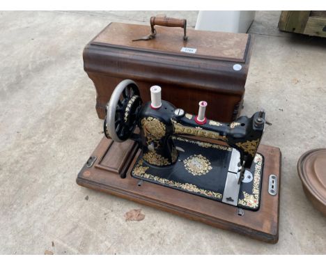 A VINTAGE JONES SEWING MACHINE WITH WOODEN CARRY CASE 