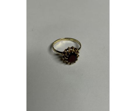 A 9CT YELLOW GOLD AND GARNET RING, SIZE K 