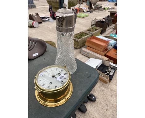 A VINTAGE BRASS CLOCK AND A CLARET JUG 