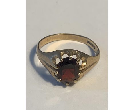 A VINTAGE 9 CARAT GOLD RING WITH A CENTRE GARNET 