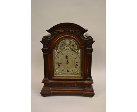 Edwardian mahogany bracket clock, the moulded arched pediment with applied carved decoration above a silvered dial with silve