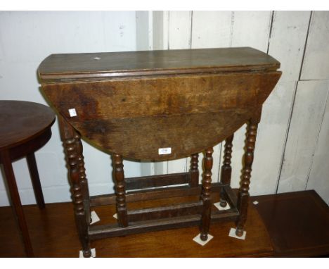 Small oak oval gate leg table on bobbin turned supports with stretchers
