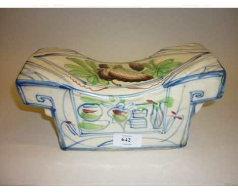 Chinese pottery pillow decorated with stylised flowers and insects in shades of green, blue and red on a beige ground, red wa