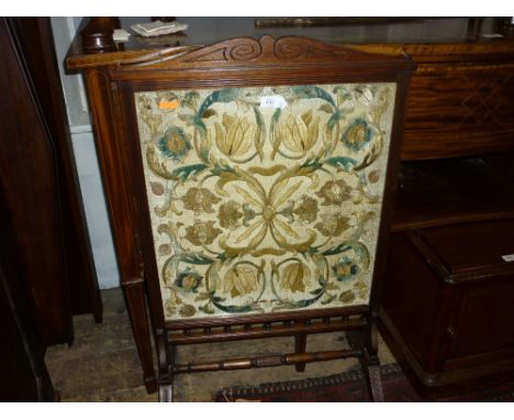 Edwardian oak firescreen inset with a silk work floral panel on splay supports with turned stretcher