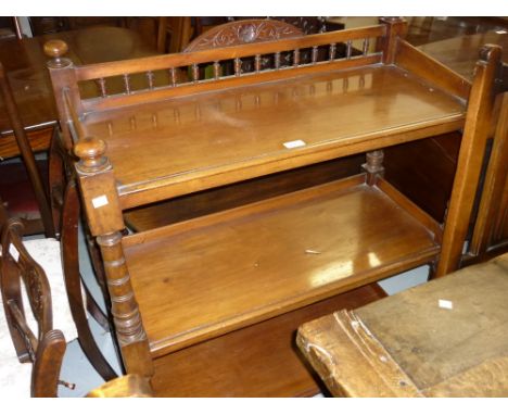 Victorian mahogany three tier buffet, the spindle galleried back above three moulded shelves on turned supports with casters