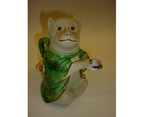 Small Chinese pottery teapot in the form of a monkey with floral enamel decoration on a green ground, signed with seal mark t