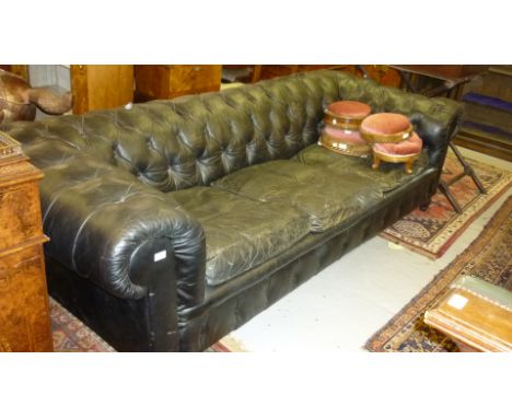 20th Century black buttoned leather upholstered three seater Chesterfield sofa raised on turned front supports