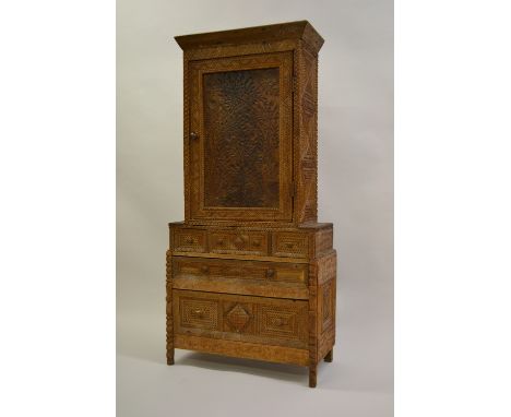 Unusual American Tramp Art side cabinet with all-over chip carved decoration, the moulded cornice above a panelled door with 