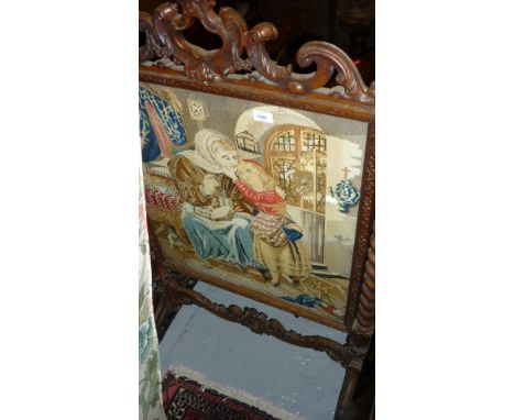 Victorian carved walnut firescreen housing a contemporary needlework panel depicting a mother and child in an interior