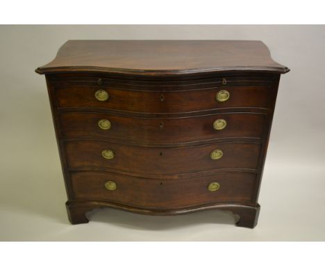 George III mahogany serpentine commode, the figured moulded top above a brushing slide and four graduated drawers with oval g