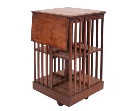 An Edwardian oak revolving bookcase, early 20th century; the square top with moulded edges and a hinge out book rest (lacking