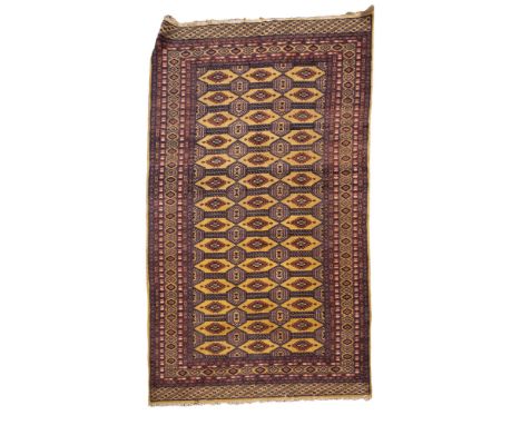 A Turkoman rug, the shaded wine geometric field with three rows of quartered guls, enclosed by a geometric stellar border, 14