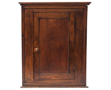 A George III oak hanging corner cupboard, late 18th century; with reeded cornice above a panel door and moulded base; 116cm h