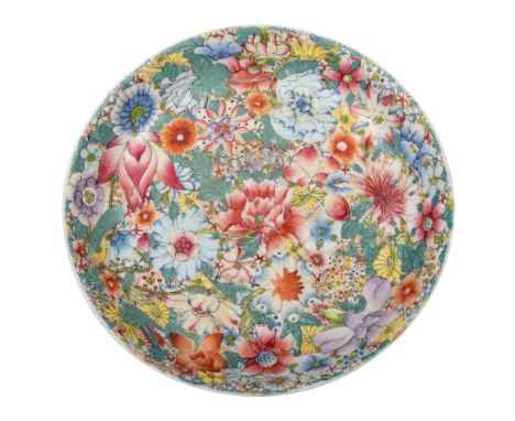 A Chinese famille rose millefleur saucer dish enamelled overall with colourful flowers and foliage, apocryphal Kangxi seal ma