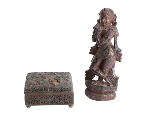 A Chinese lacquer cased enamel box and an Indian hardwood carving of a deity the box carved with a pagoda lake scene with fig
