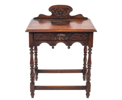 A late Victorian carved oak rectangular side table with shaped ledge back and C-scroll panel, the arcaded and foliate frieze 