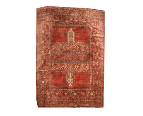 A Louis de Poortere carpet of Turkoman Hatchli design, machine made, with a brick red field and hexagonal panel border, with 