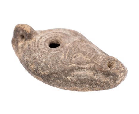 A Roman pottery oil lamp, probably 2nd/3rd century A,D.; of oval form, the top with relief moulded face between the two apert