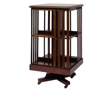 An Edwardian mahogany and crossbanded revolving bookcase, early 20th century; the top with moulded edges, above open sides wi