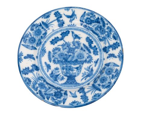 A blue and white delftware charger, German or Dutch painted with a large vase of flowers, floral sprays, birds and insects, c