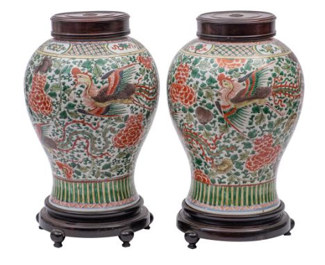 A pair of Chinese wucai 'Phoenix' jars of baluster form, decorated with phoenix flying amongst scrolling peonies, foliage and
