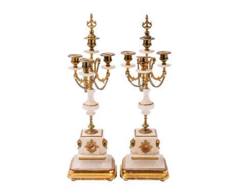 A pair of Continental alabaster and gilt metal mounted four light candelabra, circa 1880; each with a central raised urn sock