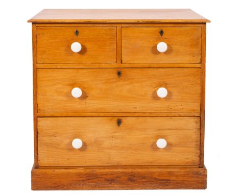 A Victorian Heals pine rectangular chest with a moulded top containing two short and two long drawers with white ceramic hand