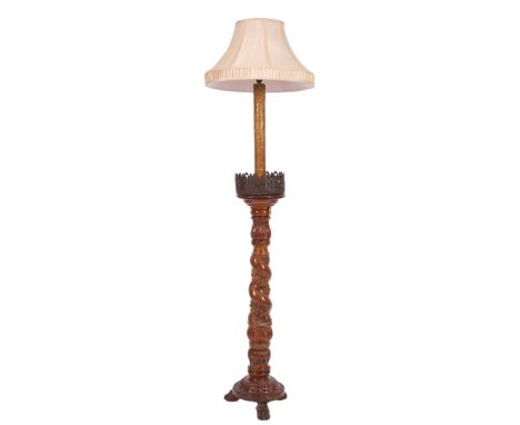 A Continental carved wood standard lamp, elements 17th century and later adapted; the faux candle upper shaft descending into