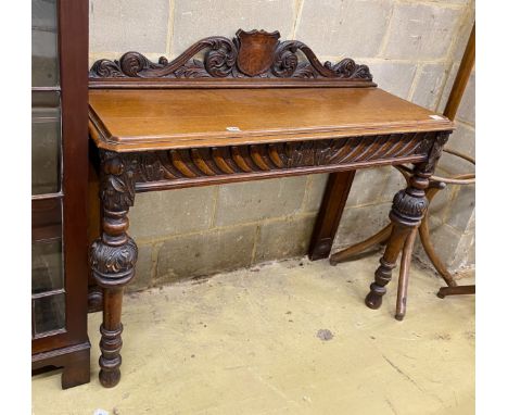 A Victorian oak console table, vacant shield cartouche and scrolling acanthus surmount to back, width 120cm, depth 42cm, heig