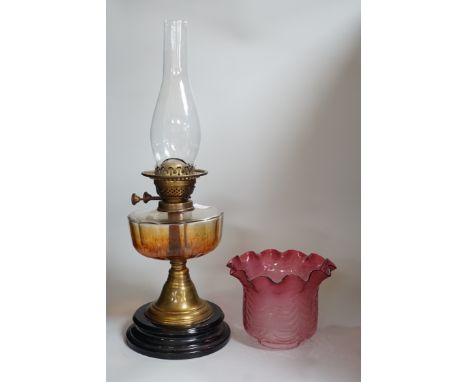 A Victorian brass and cranberry glass oil lamp