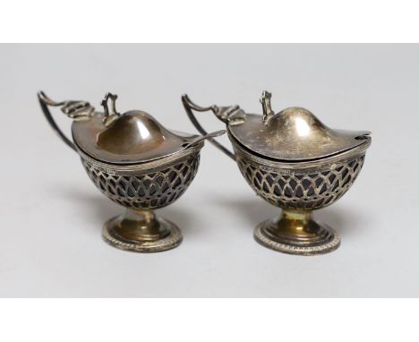 A pair of Edwardian pieced silver pedestal boat shaped mustard pots, E.S. Barnsley &amp; Co, Birmingham, 1903, length 91mm, o