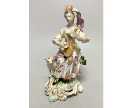 A Derby porcelain figure, modelled as a shepherdess playing a mandolin, seated on a stump, 18th century, 18cm high