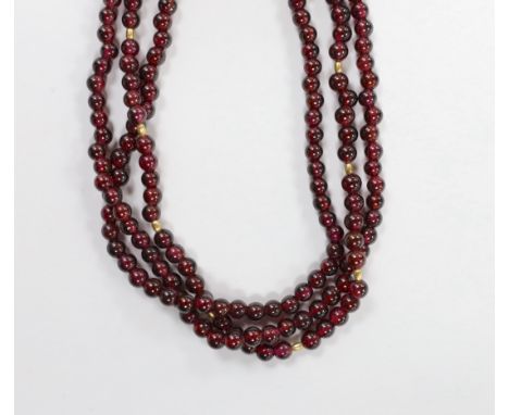 A Tiffany &amp; Co triple strand garnet bead necklace, with 750 clasp and spherical spacers, 48cm, in a Tiffany &amp; Co box.