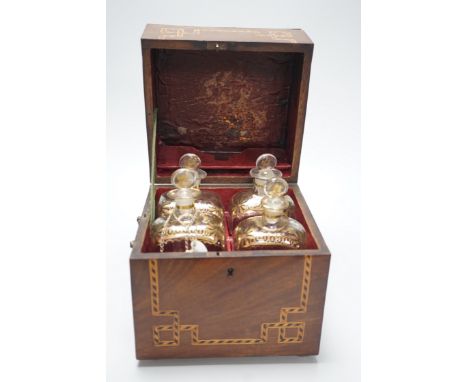 A George III inlaid mahogany decanter set with four gilt decorated decanters and two T.Goode &amp; Co. enamelled wine labels,