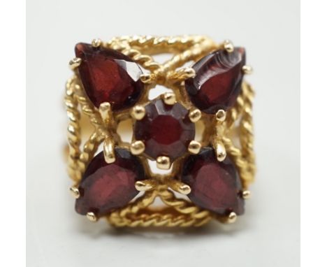 A modern 585 yellow metal and five stone garnet cluster set dress ring, size K/L, gross weigh 7.4 grams.