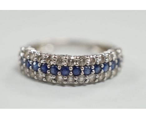 A modern 750 white metal, sapphire and diamond set three row half hoop ring, size M, gross weight 2.5 grams.