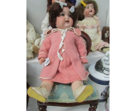 A porcelain headed doll marked A & M, 47cm/18.5", some damage to body