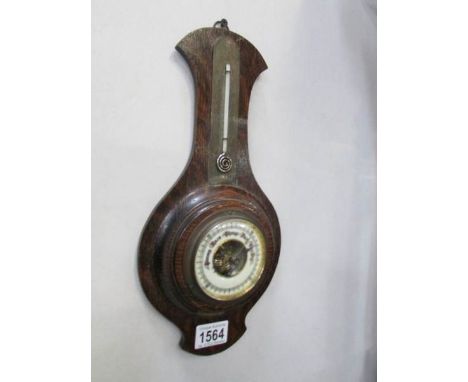 An Edwardian oak barometer with mercury snail thermometer