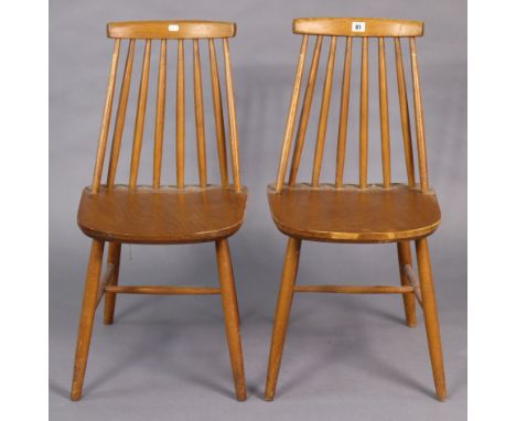 A pair of Ercol? spindle-back kitchen chairs with hard seats, &amp; on round tapered legs with spindle stretchers.