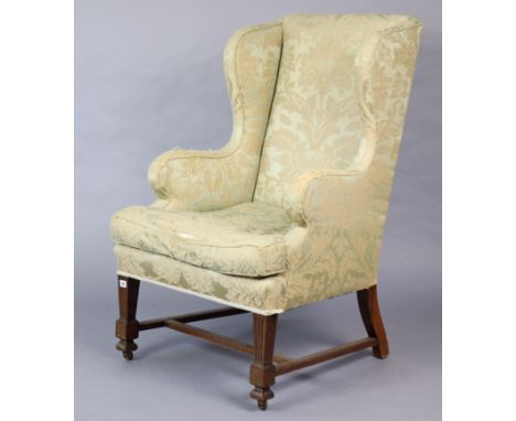 A Late 19th/early 20th century wing-back armchair (requires re-upholstery), on short square fluted legs &amp; ceramic castors