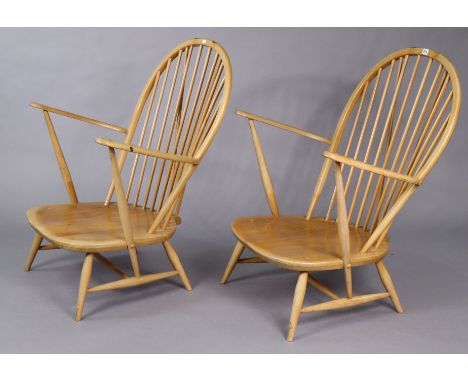 A pair of Ercol light elm armchairs each with spindles to the open hooped back, with hard seat, and on short round tapered le