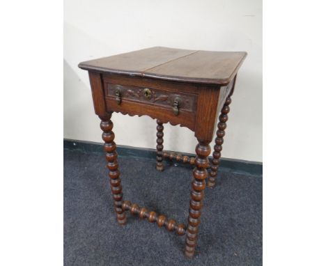 A 19th century carved oak occasional table fitted a drawer on bobbin legs 
