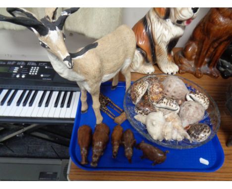 A tray of model of an antelope, hardwood animal carvings, sea shells, glass bowl 