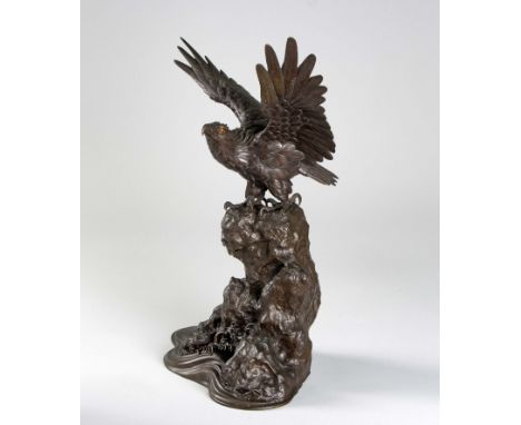 Perched with large talons gripping a shaped rock above foaming waves, the wings spread wide, the feathers realistically cast 