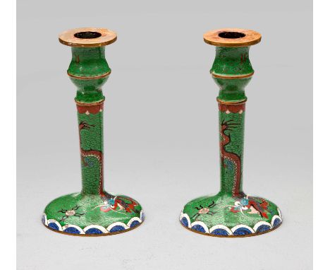 Each emerald-green candlestick enamelled with a coiling iron-red dragon above a band of blue and white waves, age wear15cm hi