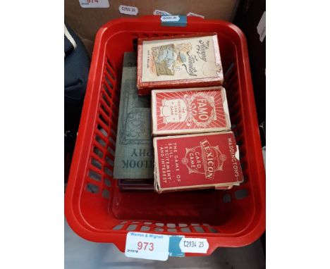 A basket containing three vintage card games and some old books 