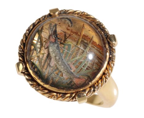 AN ESSEX CRYSTAL ANGLERS RING depicting a fish amongst reeds, within an unmarked gold rope effect mount and shank, ring size 